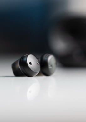 Sony E10 rechargeable hearing aids on table.
